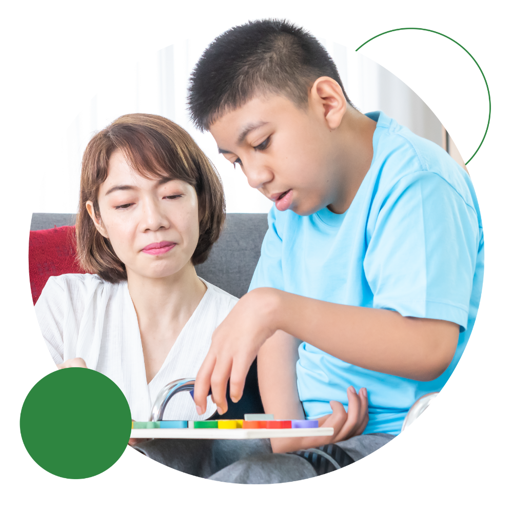 Adult-Assisting-A-Childs-Learning-At-Table 1 An adult supporting a child’s learning journey at the table, assisting with an education activity - a snapshot of care transformation in action