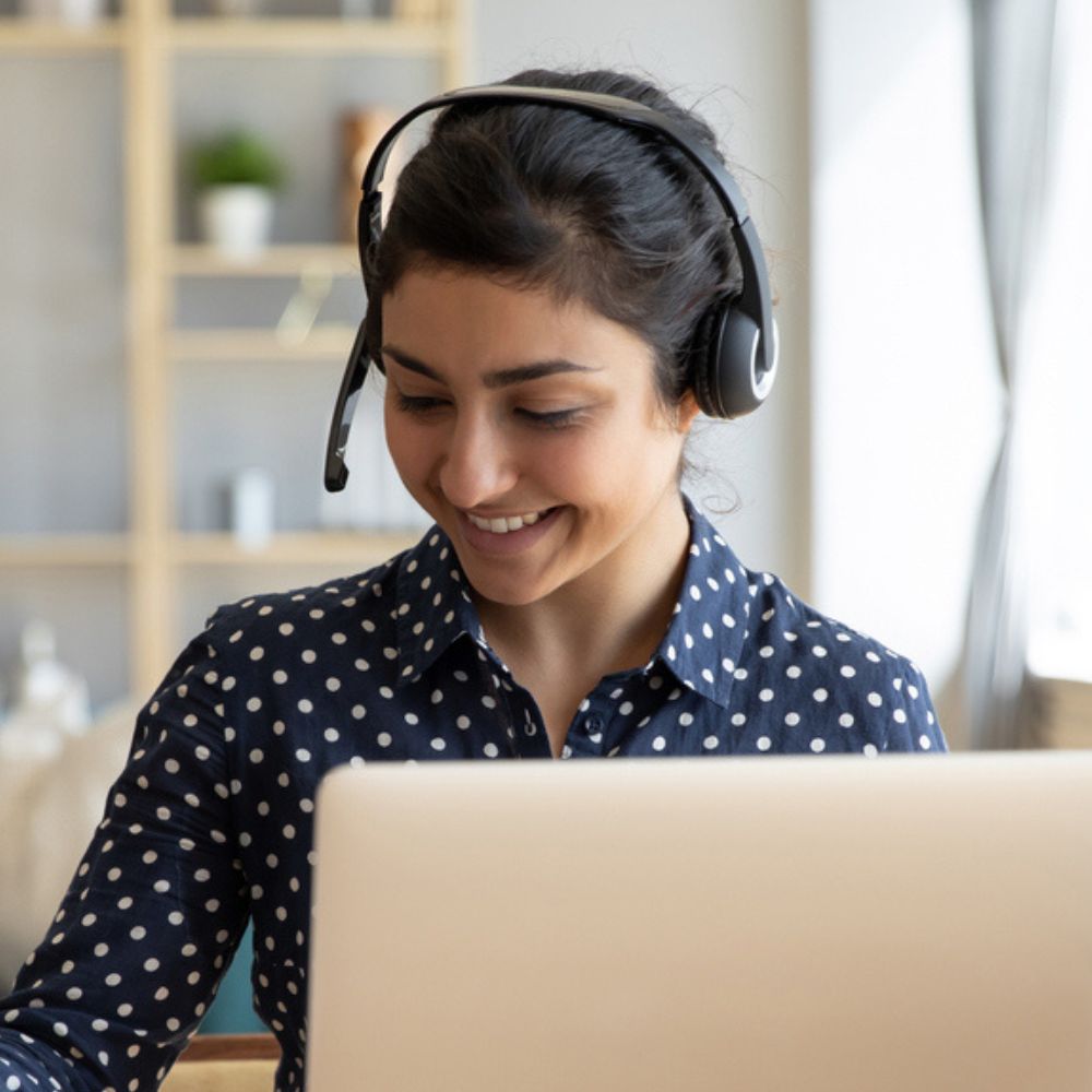 Liaison Care staff using a laptop and pen, providing remote care services to ICBs.