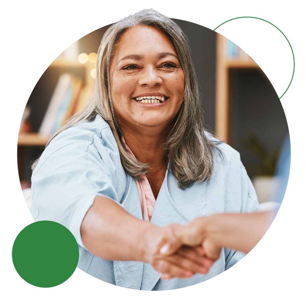 a smiling continuing healthcare funded patient shaking hands with another person in front